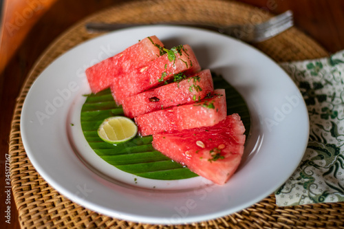 Balinese breakfast served in a white plate with watermelon and lemon piece