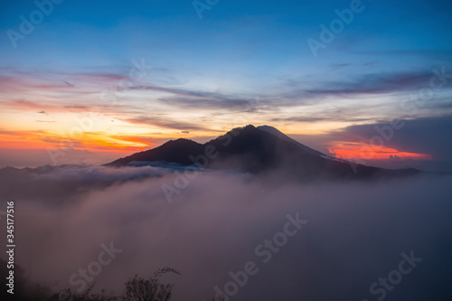 A magnificent view of kintamani volcano from the top of the Mount Batur during the sunrise with fog