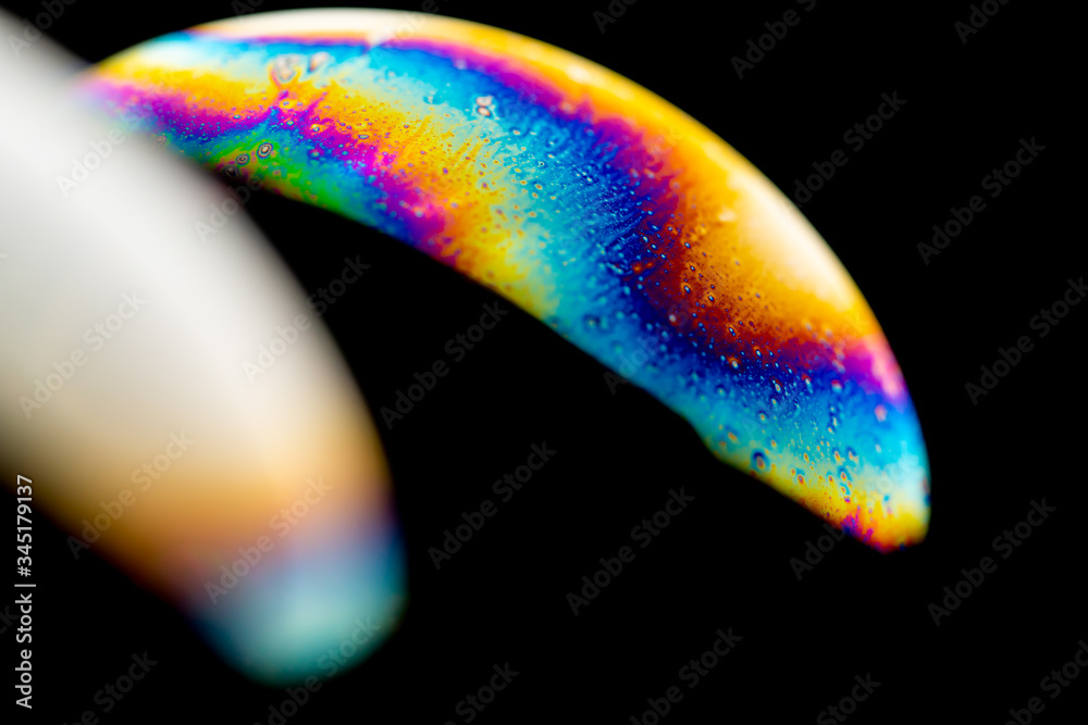 Psychedelic abstract planet from soap bubble, Light refraction on a soap bubble, Macro Close Up in soap bubble. Rainbow colors on a black background. Model of Space or planets universe cosmic galaxy.