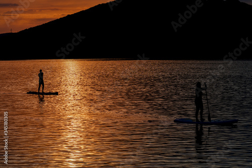 Sup boarding couple on sunset