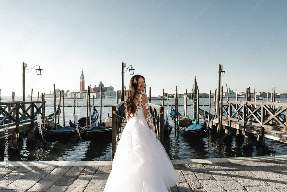 Obraz premium beautiful bride dressed in a wedding dress and stands near the pier,fashionable wedding dress,smiling bride in dress,