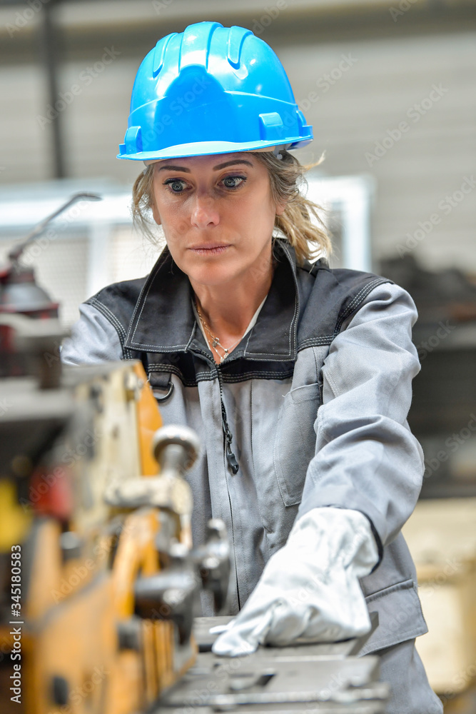 Concentrate woman worker using a punching machine Concentrate woman worker using a punching machine