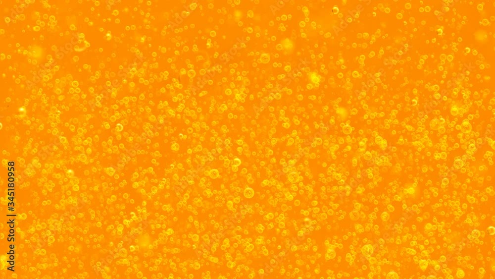 Upward movement of small bubbles on orange background. For advertising: beer, juice, water, fuel, shampoo, soda water and any other liquid Upward movement of small bubbles on orange background. For advertising: beer, juice, water, fuel, shampoo, soda water and any other liquid