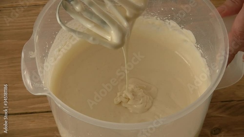 a woman with a mixer mixes the dough for a pie