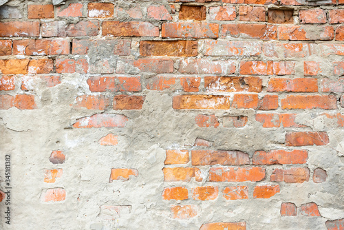 Texture of an old broken brick wall of red burnt brick. Background of ancient brickwork with cement mortar