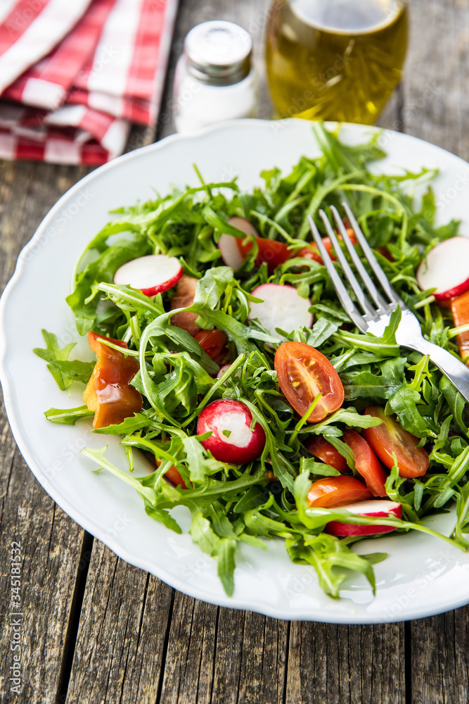 Fresh arugula salad with radishes, tomatoes and red peppers. Fresh arugula salad with radishes, tomatoes and red peppers.