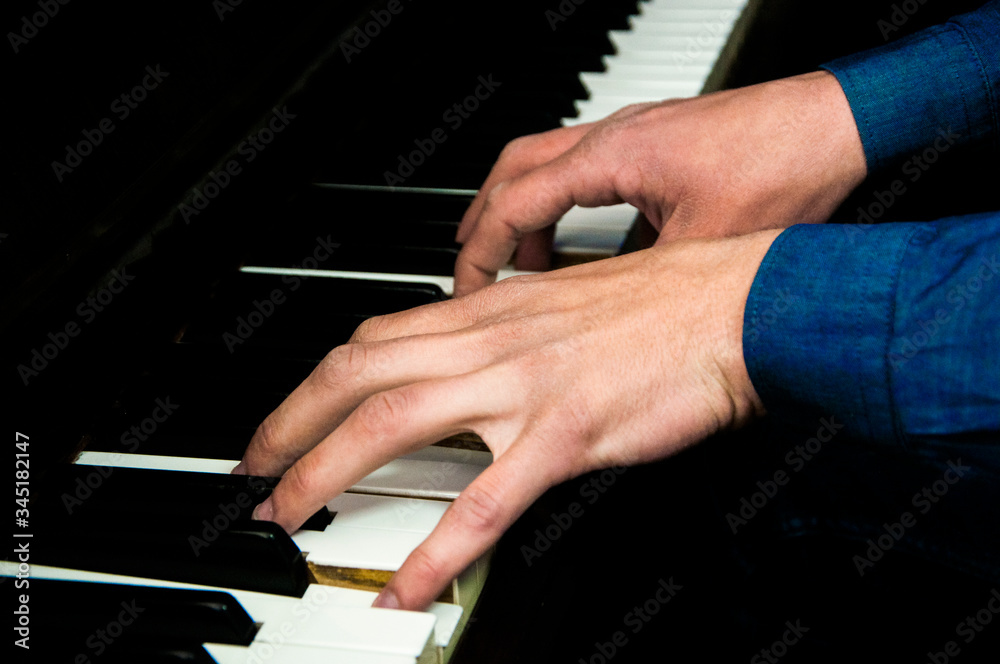 the musician accompanies the piano. man plays a musical instrument. male fingers on the keys