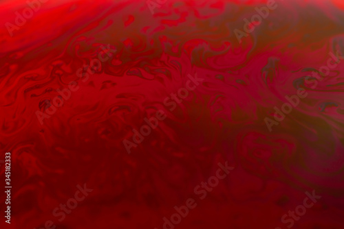abstract background of iridescent paints in red colors