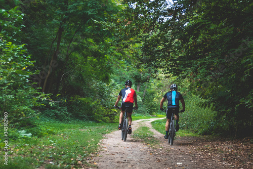 a group of sports cyclists ride a mountain bike through the forest