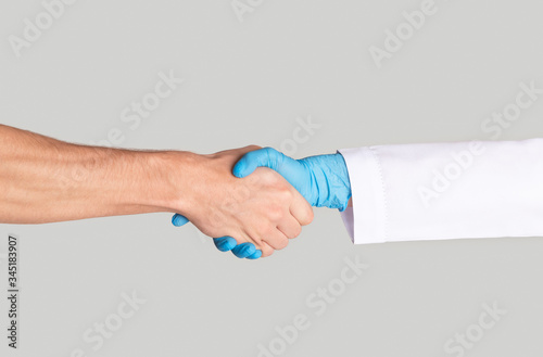 Wallpaper Mural Male patient shaking hands with his doctor on light background, close up Torontodigital.ca
