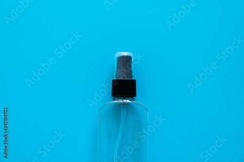 Bottle of antiseptic, a bottle of hand sanitizer, hand sanitizer spray on a blue background, for the prevention of coronavirus. Bottle of antiseptic spray mockup, copy space for design. © Volodymyr