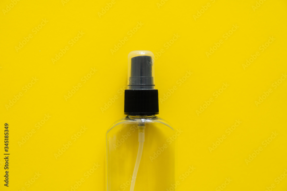 Bottle of antiseptic, a bottle of hand sanitizer, hand sanitizer spray on a yellow background, for the prevention of coronavirus. Bottle of antiseptic spray mockup, copy space for design.