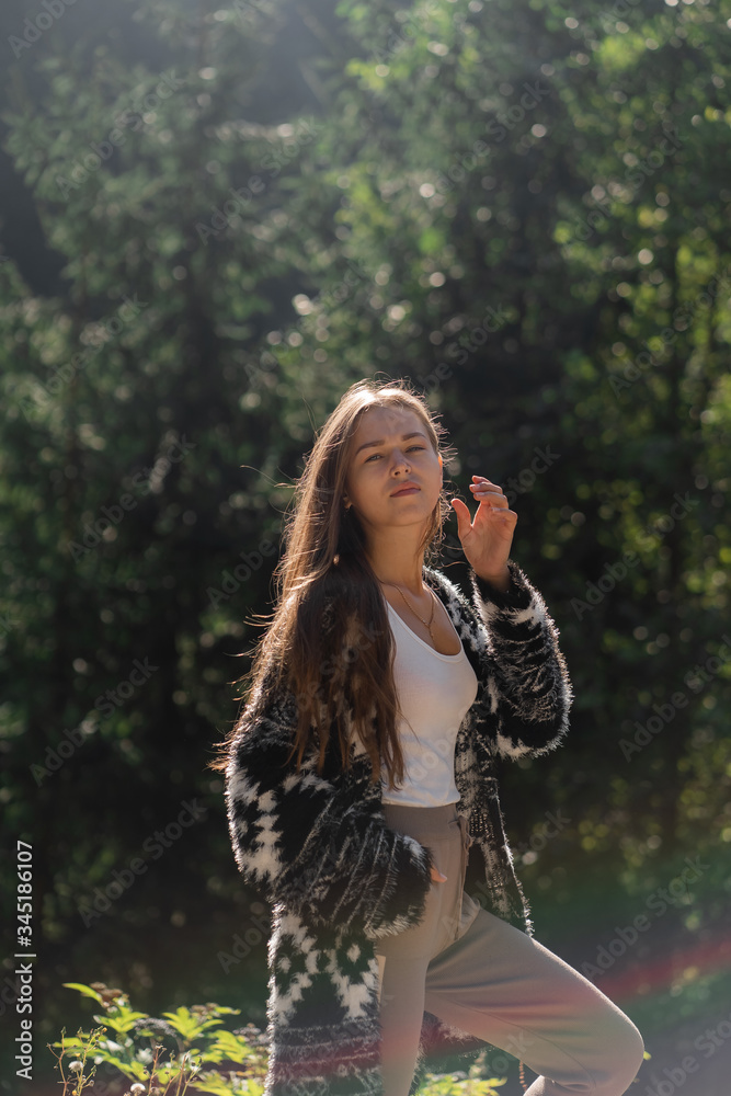 Outdoor photo of brunette lady posing in forest.Fashion street style portrait. wearing gray casual trousers, white t-shirt.Fashion, relax and nature concept.