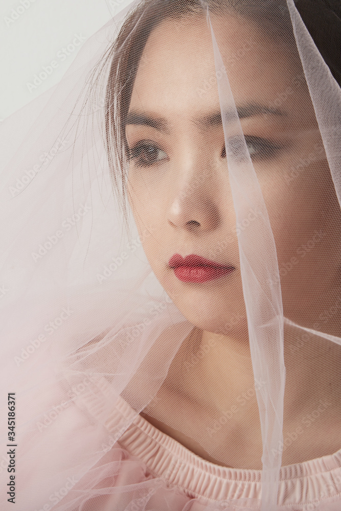 Vertical close-up portrait of asian woman in bridal make up and hair style. Pink studio background. Space for your text. Vertical close-up portrait of asian woman in bridal make up and hair style. Pink studio background. Space for your text.