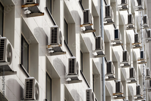 On the facade of the office building there are air conditioners at the Windows. Concept of indoor climate and air circulation