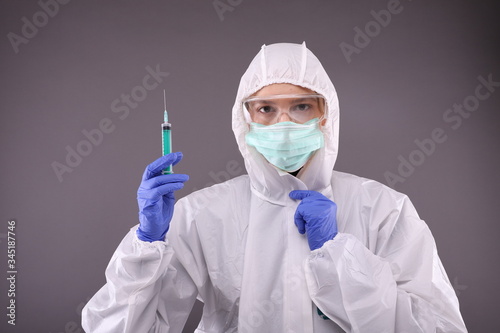 Woman in protective costume with vaccine against coronavirus