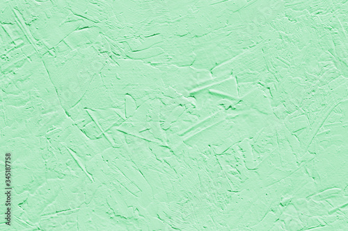 Abstract decorative background light green painted stucco wall texture. Handmade rough art background with copy space for design.