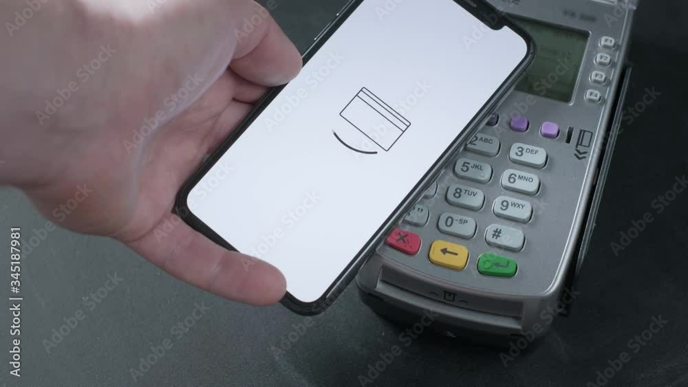 Pay by phone on the POS contactless payment terminal. A user makes a purchase using a smartphone in a store or restaurant. E-money at cashless wallet. Pay by phone on the POS contactless payment terminal. A user makes a purchase using a smartphone in a store or restaurant. E-money at cashless wallet.