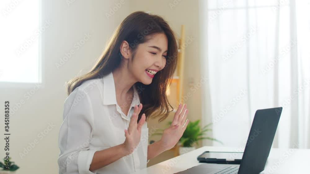 Young Asian business female using laptop video call talking with couple while working from home at living room. Self-isolation, social distancing, quarantine for coronavirus in next normal concept. Young Asian business female using laptop video call talking with couple while working from home at living room. Self-isolation, social distancing, quarantine for coronavirus in next normal concept.