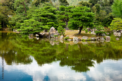 Tablou pe pânză Japanese ornamental garden  with Japanese white pines and lake near Kinkakuji Temple (kinkaku-ji) in Kyoto, Japan