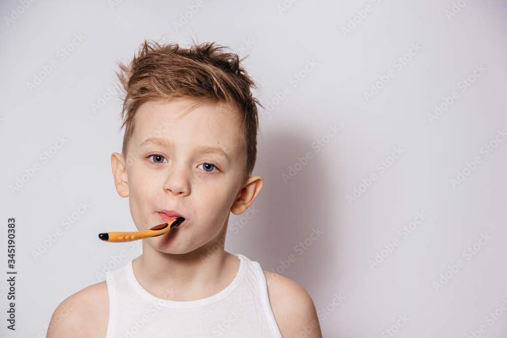 Boy brushes his teeth with a toothbrush on a white background Boy brushes his teeth with a toothbrush on a white background