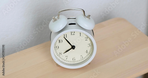 Men's hands off ringing white alarm clock. Close up. photo