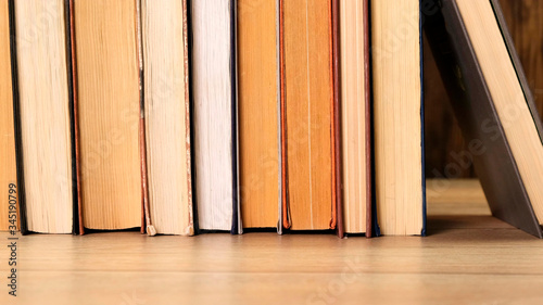 Person taking a book off a bookshelf in a library or book shop. Close up. photo