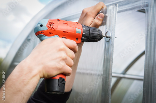 Detail of folding and assembling a greenhouse in the garden. Individual assembly steps. 