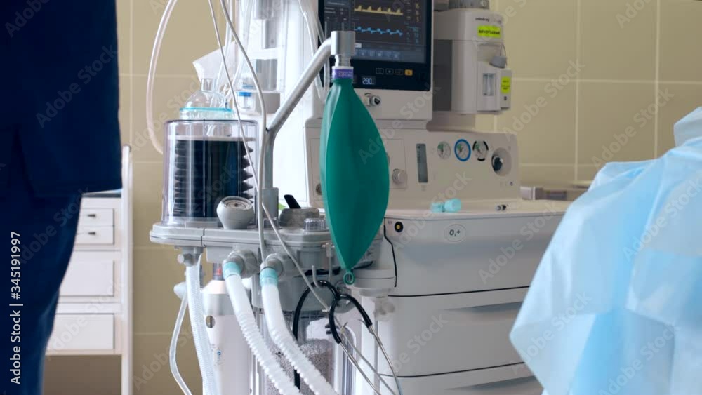 Close-up of a ventilator during an operation, 4k shot. The movement is remembered by artificial lung ventilation, amid a ward with a patient and doctors. Pneumonia and tuberculosis, Covid 19 Close-up of a ventilator during an operation, 4k shot. The movement is remembered by artificial lung ventilation, amid a ward with a patient and doctors. Pneumonia and tuberculosis, Covid 19