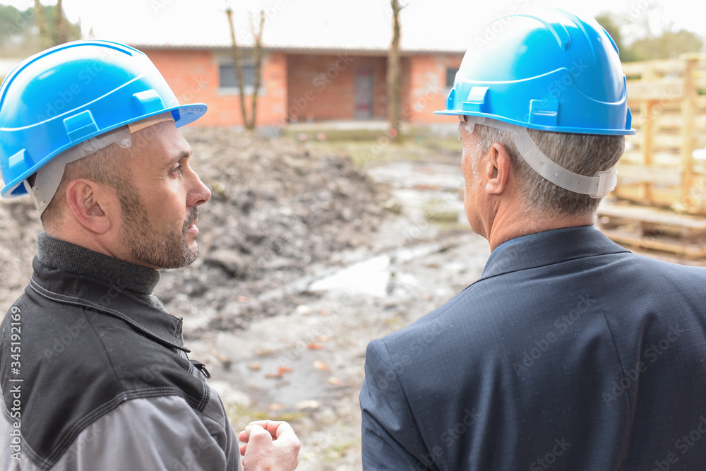 Owner and contractor outsides the construction site Owner and contractor outsides the construction site