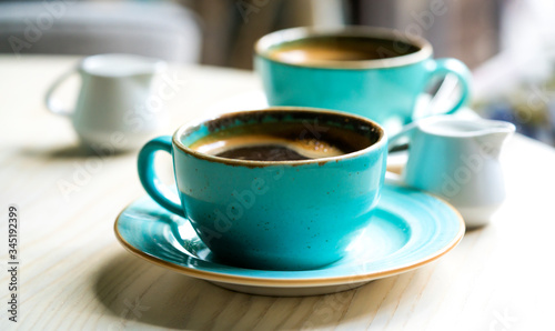 .two green cups with coffee on the table