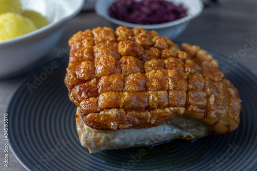 Pork roast with crackling on a black plate  ready to eat
