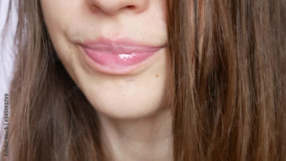 A mouth of a young beautiful woman drinking the beer from a glass close up A mouth of a young beautiful woman drinking the beer from a glass close up