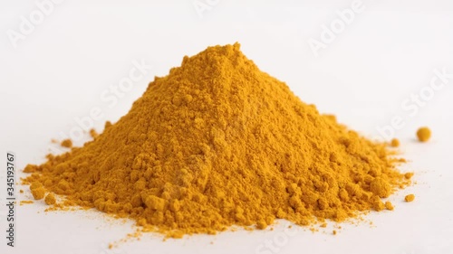 Turmeric powder or curcuma powder rotates on a white background. Turmeric isolated on a white background