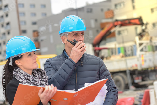 Constructtion manager and architect read their notes on a building site photo