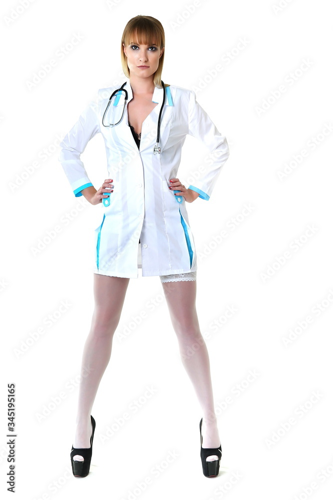 sexy woman doctor with a stethoscope standing on white background. sexy nurse in a white stockings and short white medical coat isolated on white background. sexual lady physician with long legs sexy woman doctor with a stethoscope standing on white background. sexy nurse in a white stockings and short white medical coat isolated on white background. sexual lady physician with long legs