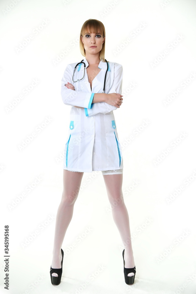 sexy woman doctor with a stethoscope standing on white background. sexy  nurse in a white stockings and short white medical coat isolated on white  background. sexual lady physician with long legs foto