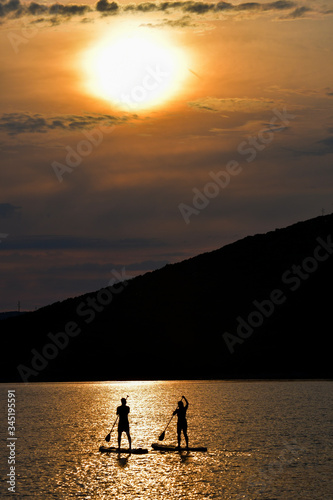 Sup boarding couple on sunset