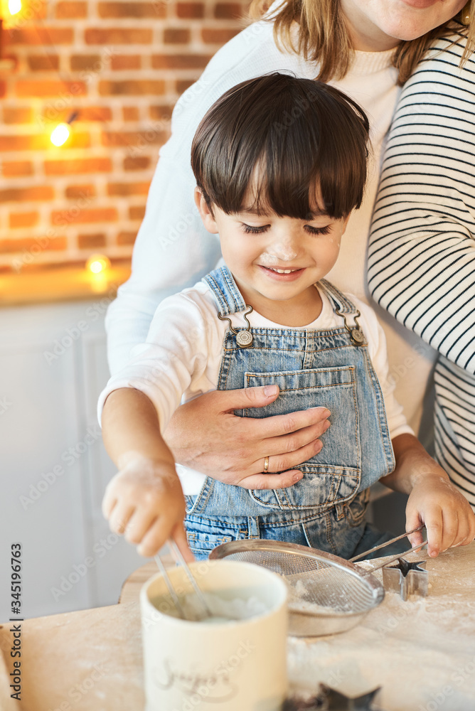 young beautiful family having fun and cooking in the sunny kitchen young beautiful family having fun and cooking in the sunny kitchen