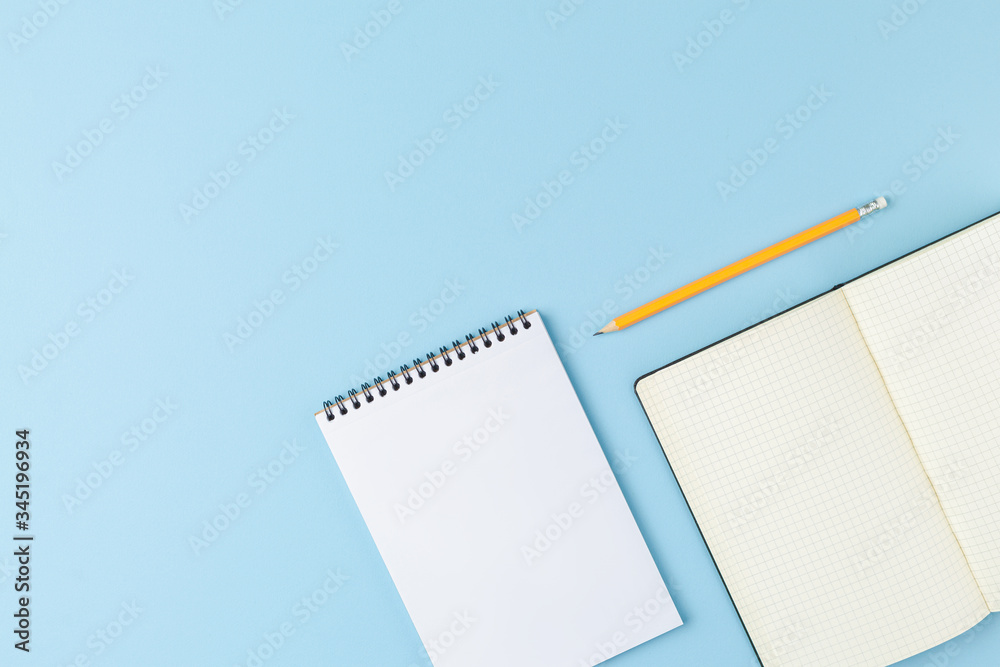 Open notebook with a pencil on blue background. Open notebook with a pencil on blue background.