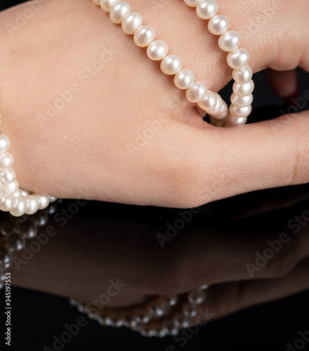 woman with pearl diamond necklace in hand
