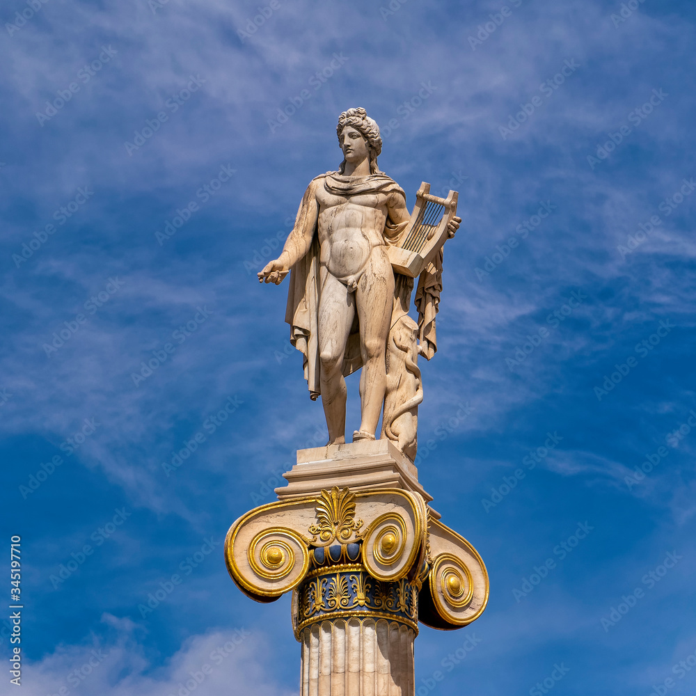 Obraz premium Apollo white marble statue on Ionian style column under blue sky with some clouds, Athens Greece