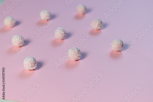 Sweet pink balls with coconut flakes on rose background