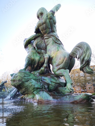 statue in hamburg park germany Stuhlmannbrunnen Sunny day Man fishing
