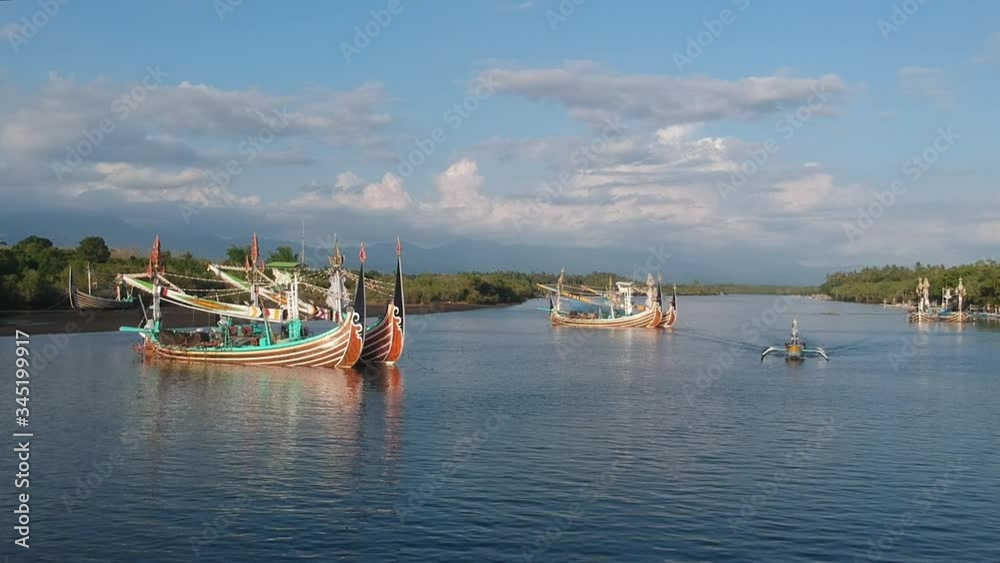 drone approach to large and beautiful Balinese boats and a small boat floats in Prancak Perancak west bali drone approach to large and beautiful Balinese boats and a small boat floats in Prancak Perancak west bali