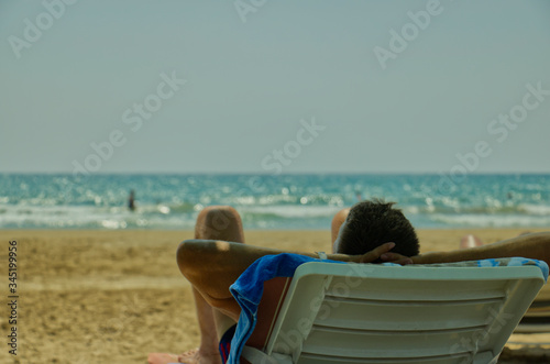 Man resting in chair at beach © Emre