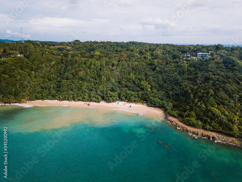 Aerial view of cozy white sand beach with turquoise clear sea water. Sri Lanka beach view from the air, Mirissa 