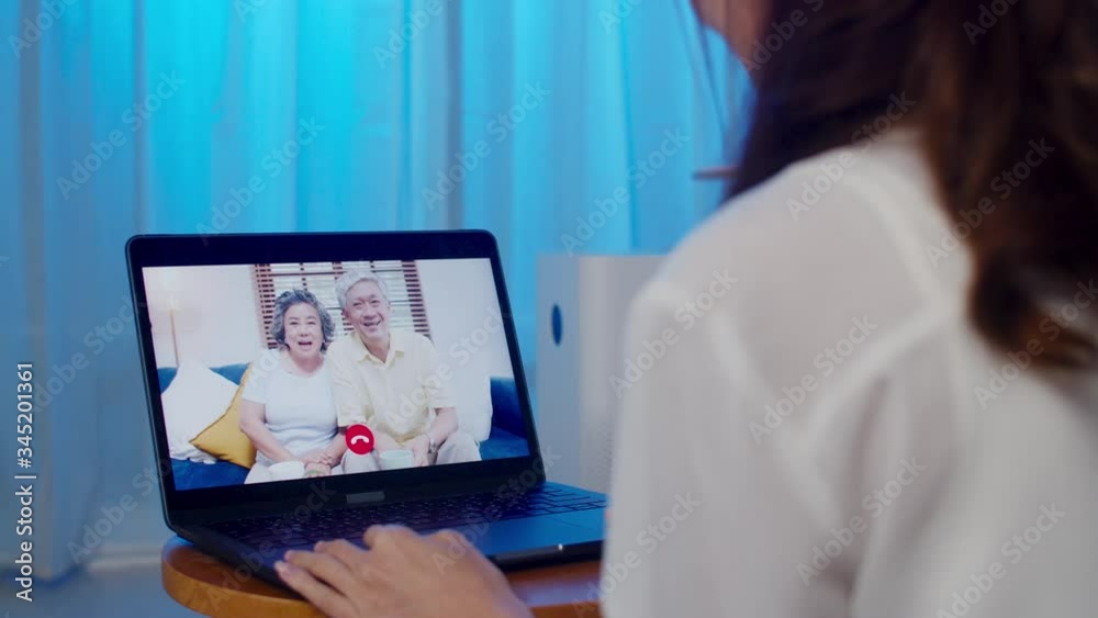 Asia student exchange female using laptop video call talking with family while working from home at living room at night. Self-isolation, social distancing, quarantine for coronavirus in next normal. Asia student exchange female using laptop video call talking with family while working from home at living room at night. Self-isolation, social distancing, quarantine for coronavirus in next normal.