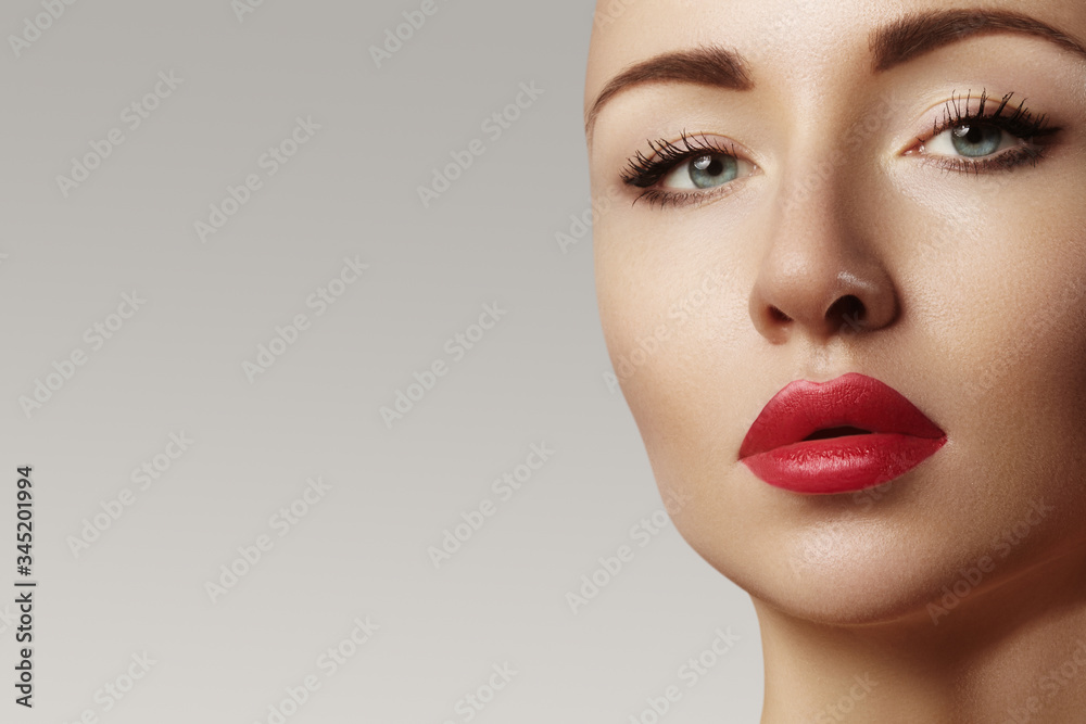 Fototapeta premium Beautiful model with fashion make-up. Close-up portrait sexy woman with glamour lips red makeup and bright eye shadows