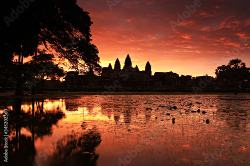 Sunrise view of popular tourist attraction ancient temple complex Angkor Wat with reflected in lake Siem Reap, Cambodia photo